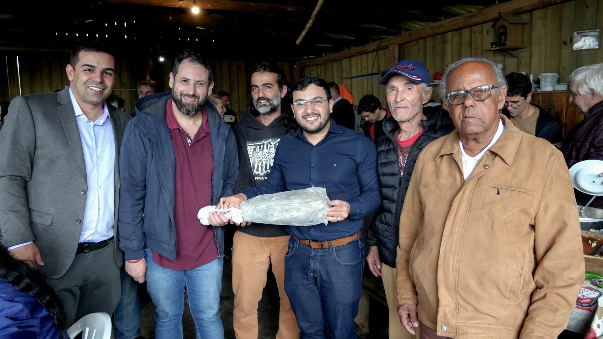Mulher colhendo tomates e pimentões em uma horta, agachada ao lado das plantas frondosas.