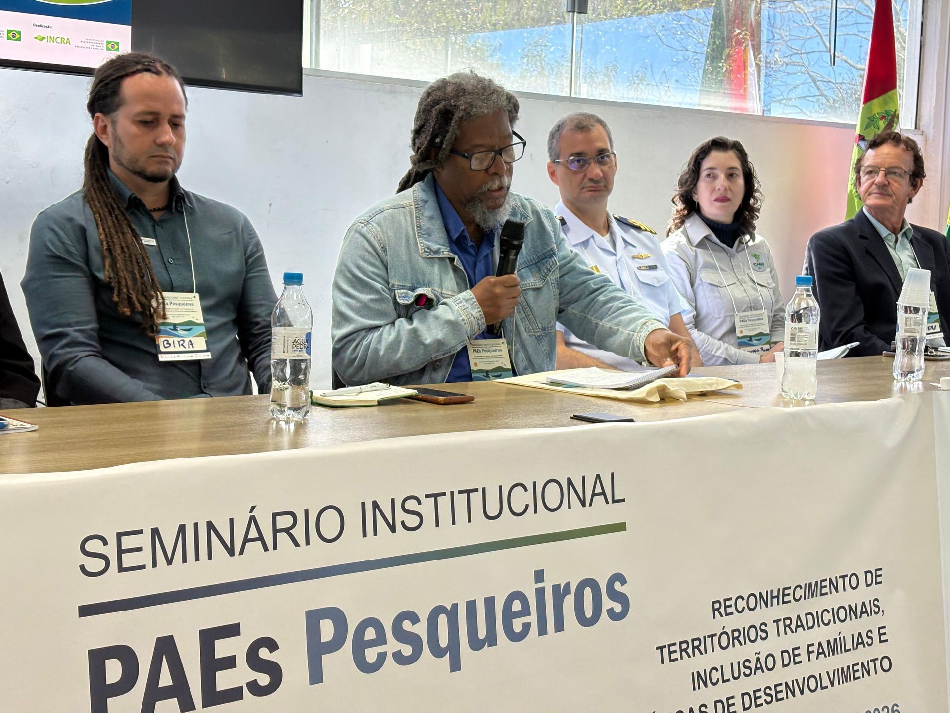Mulher colhendo tomates e pimentões em uma horta, agachada ao lado das plantas frondosas.
