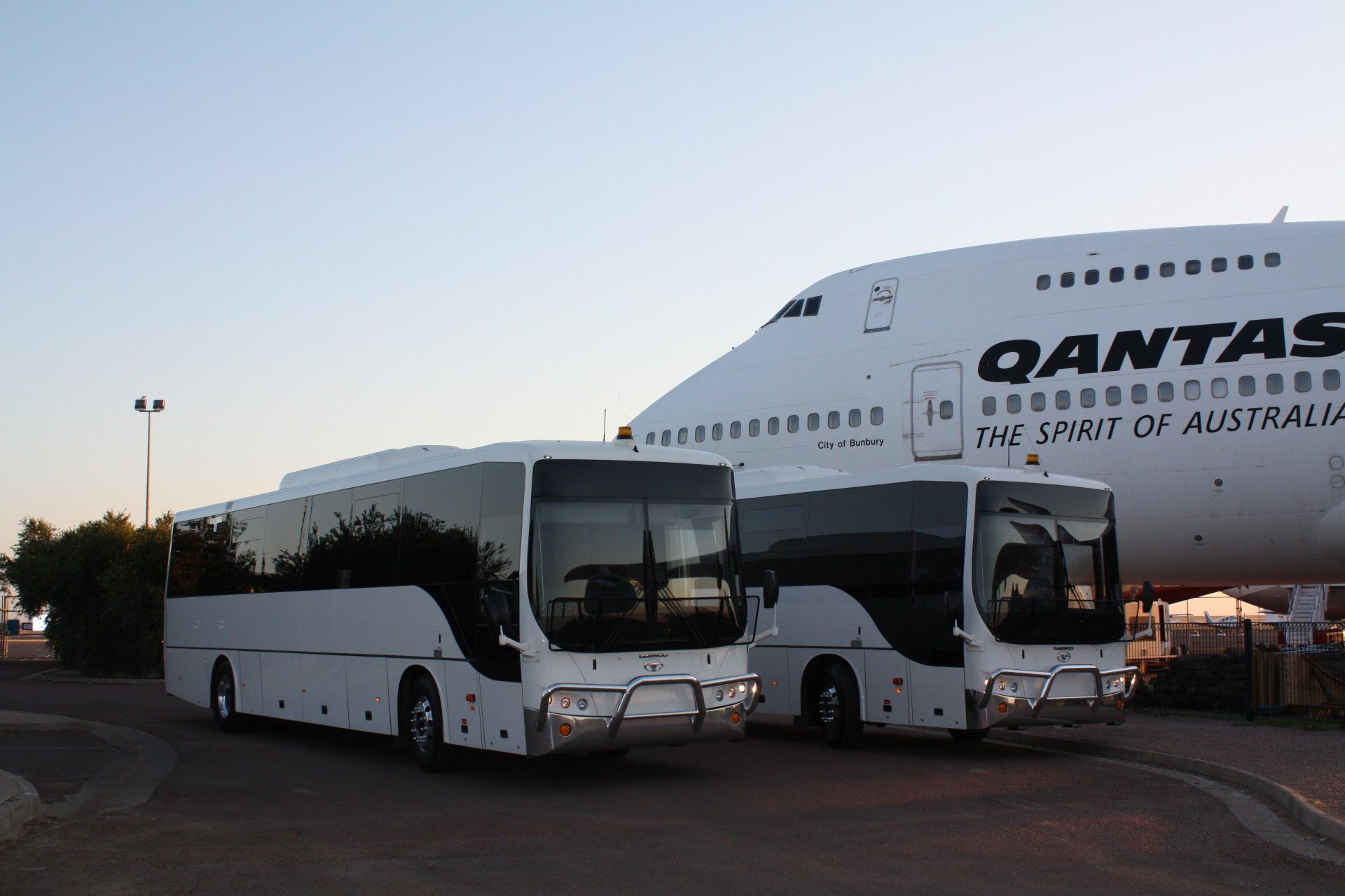 Coach Charters Australia coaches beside a Qantas aircraft for group airport transfers