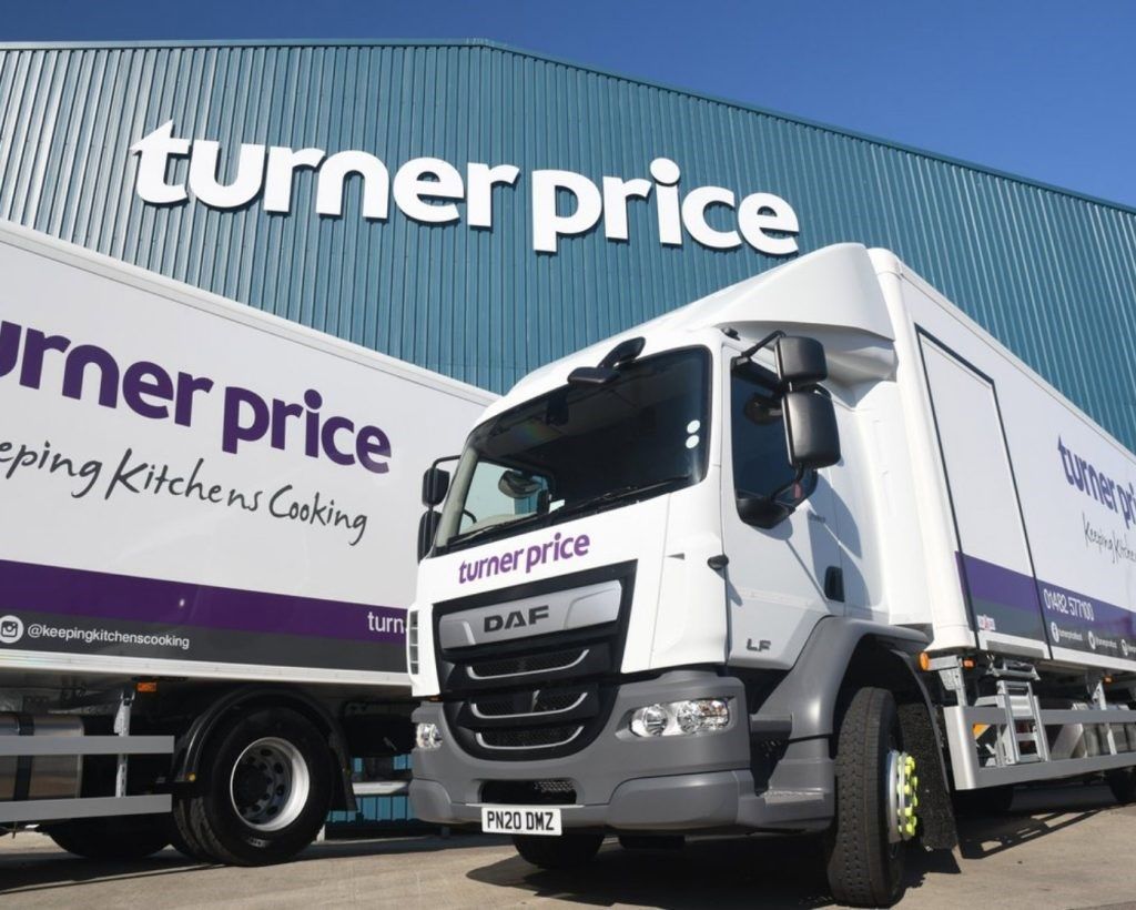 Turner Price branded lorries outside the Turner Price branded warehouse building. 