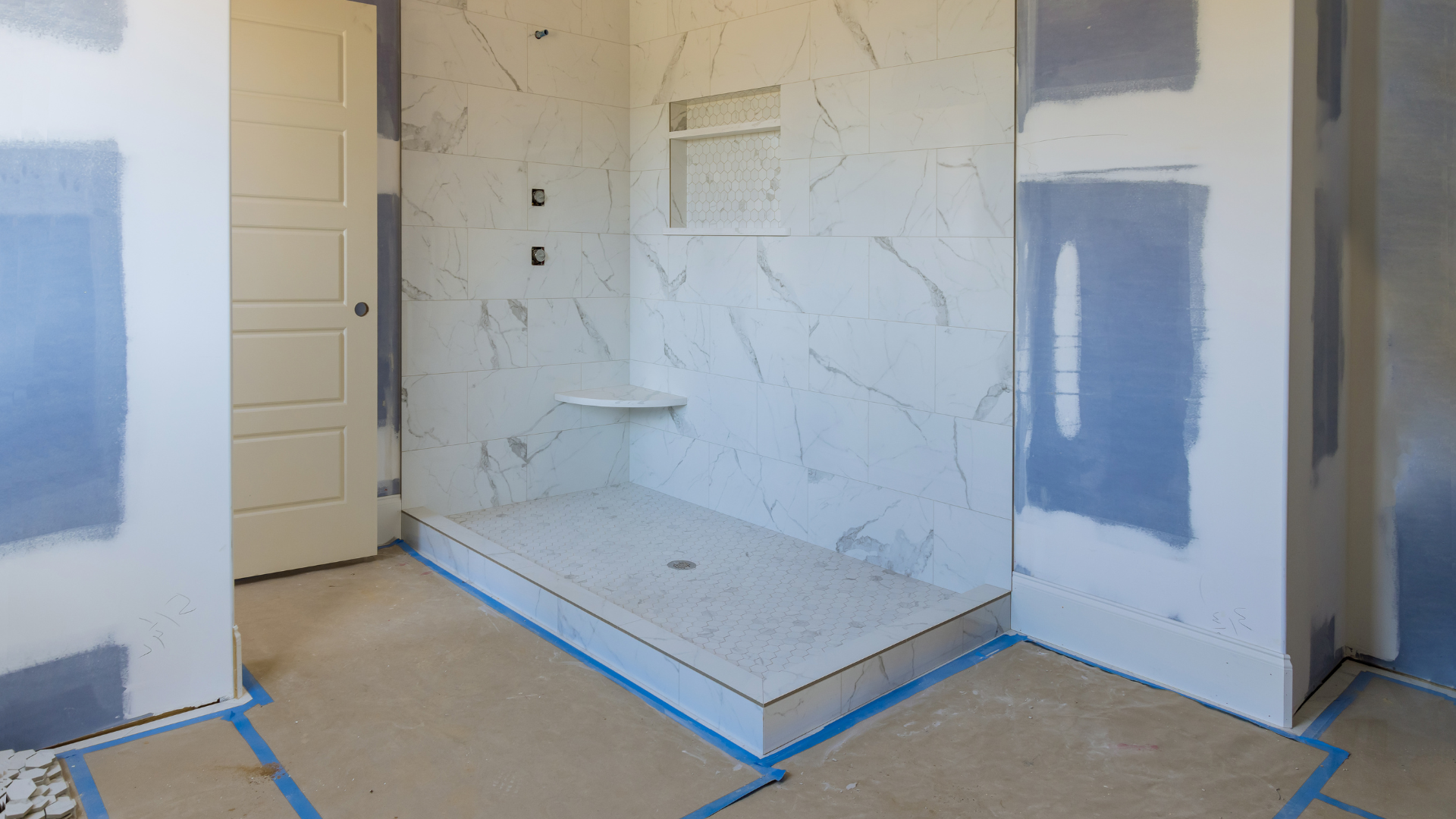 A bathroom under construction with a walk in shower.