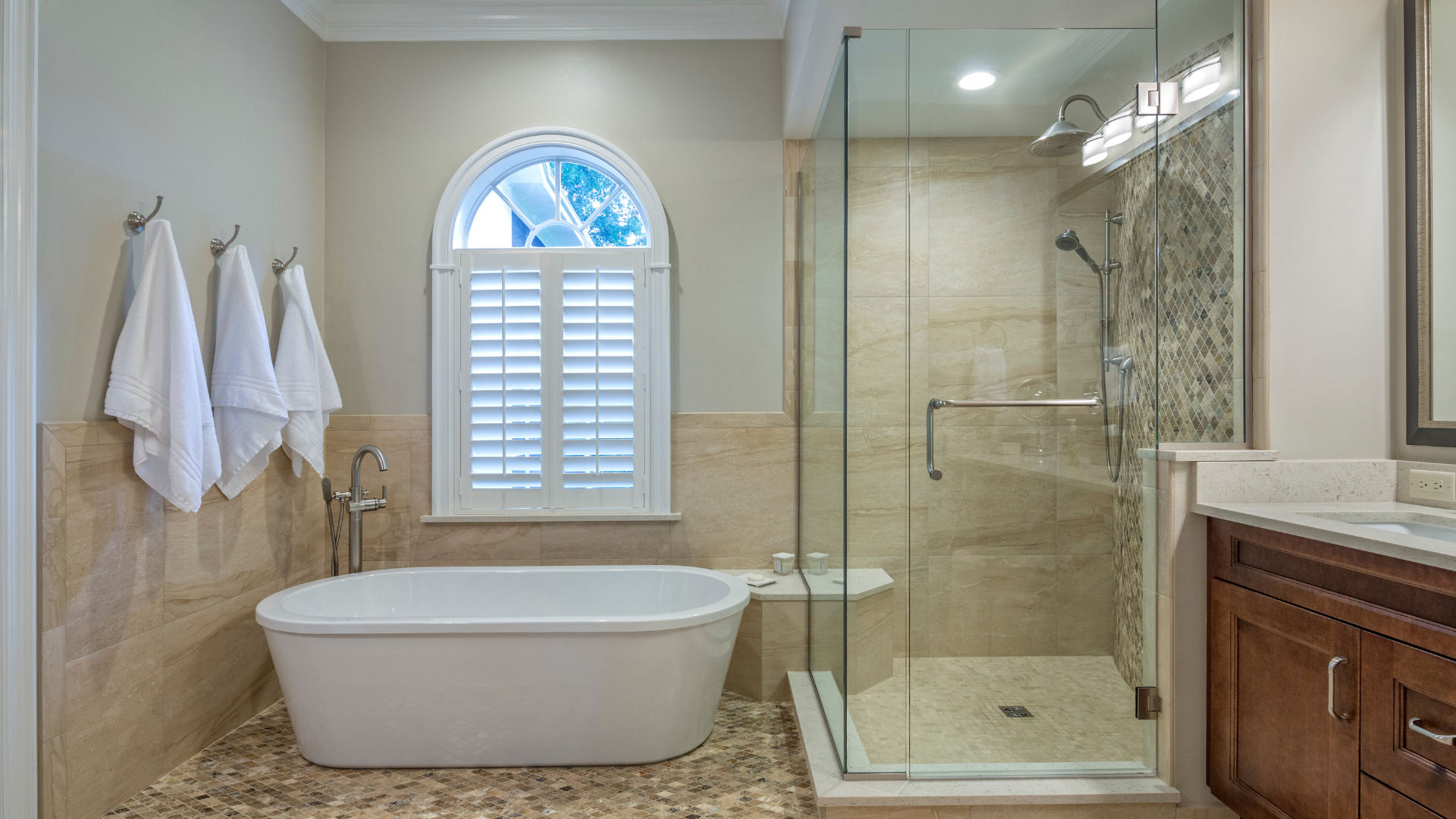 A bathroom with a tub , sink , shower and window.