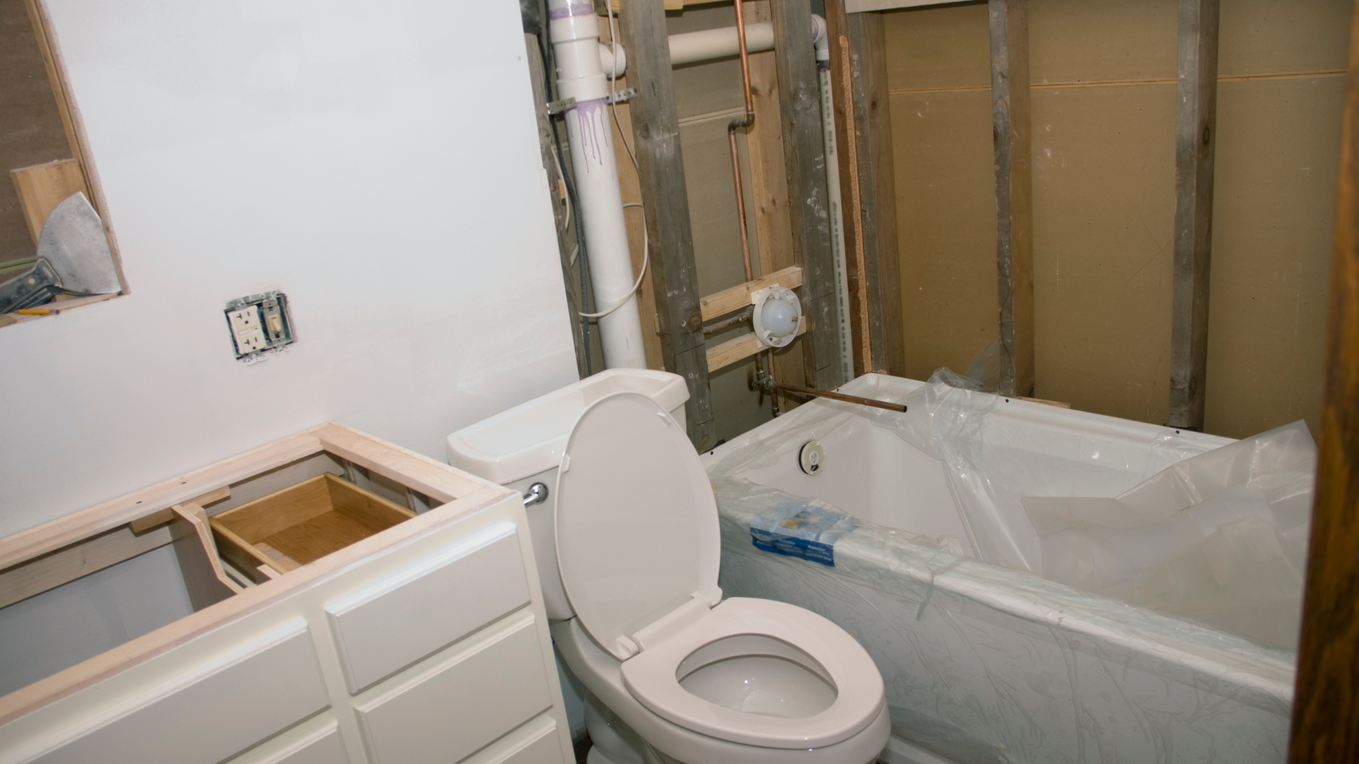 A bathroom under construction with a toilet , sink and bathtub.