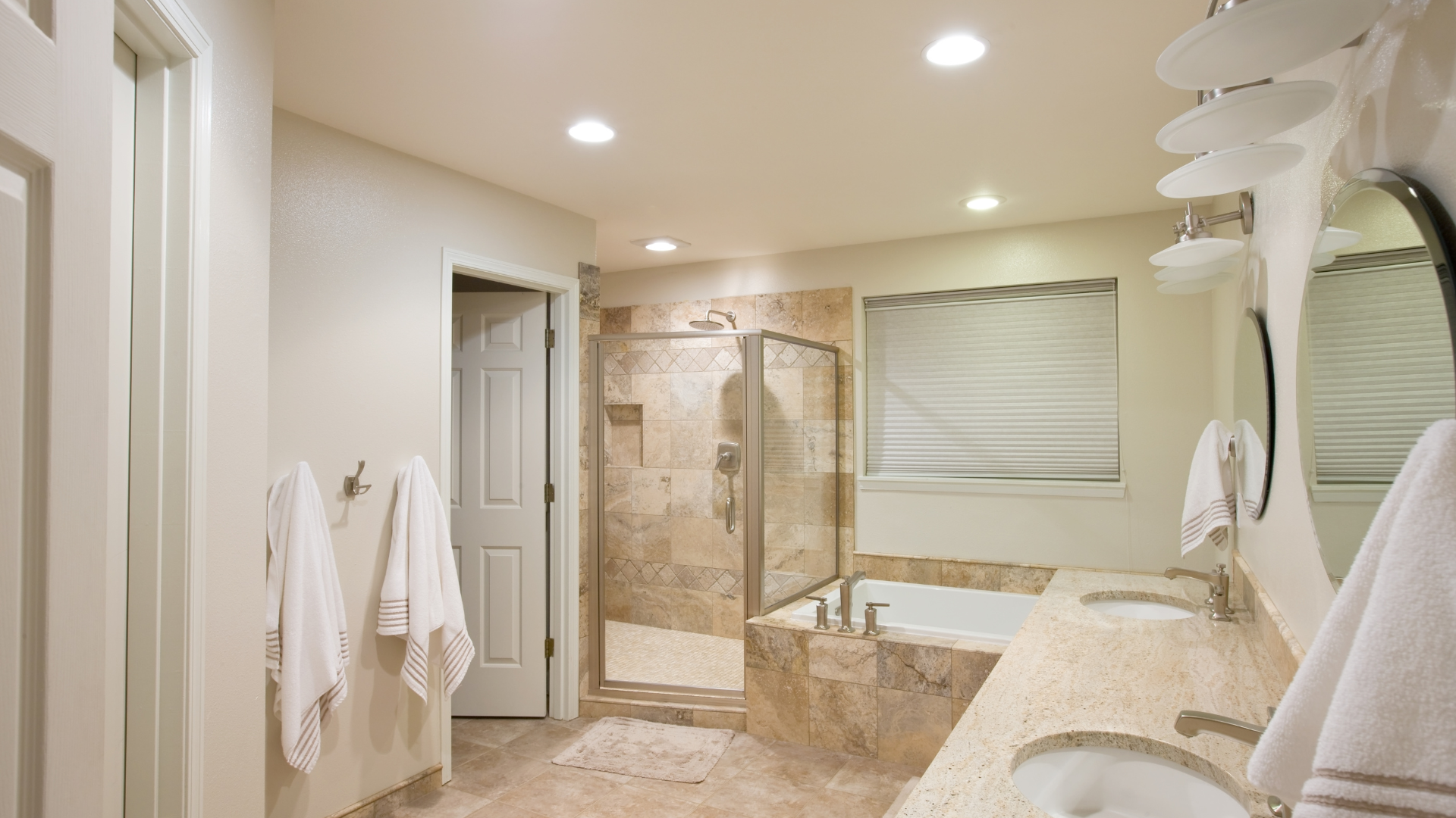 A bathroom with two sinks , a tub , and a walk in shower.