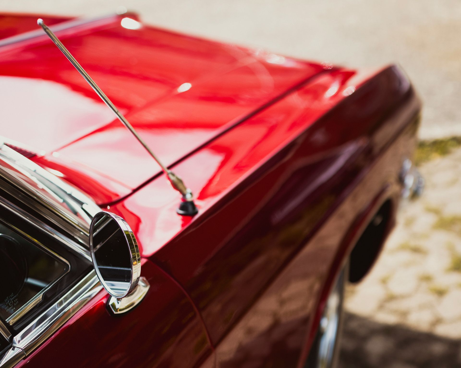 A red car with a antenna on the hood