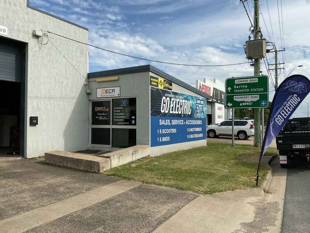 GO Electric business front with sign, on a street. Green directional sign and a black truck on the right.— EVA Motors in Paget, QLD