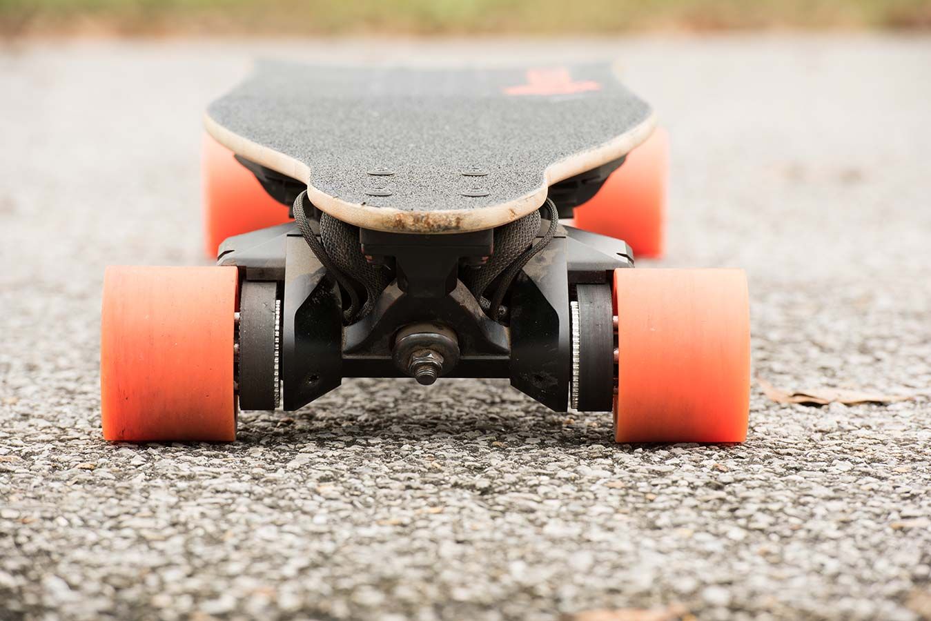A Close Up of a Skateboard With Orange Wheels on a Road — EVA Motors in Paget, QLD