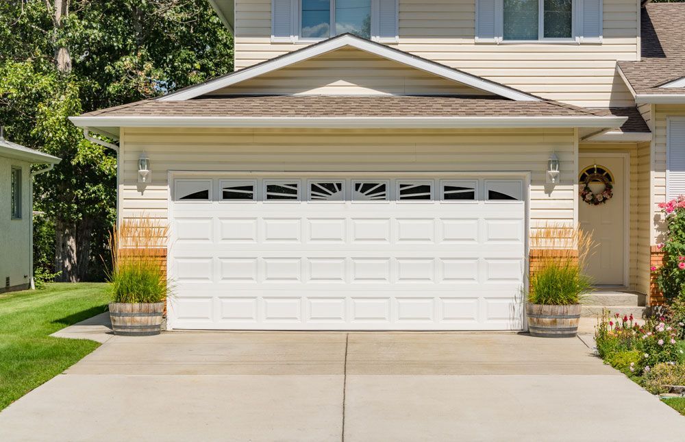 There is a Large White Garage Door in Front of a House — Hastings Garage Door Services in Port Macquarie