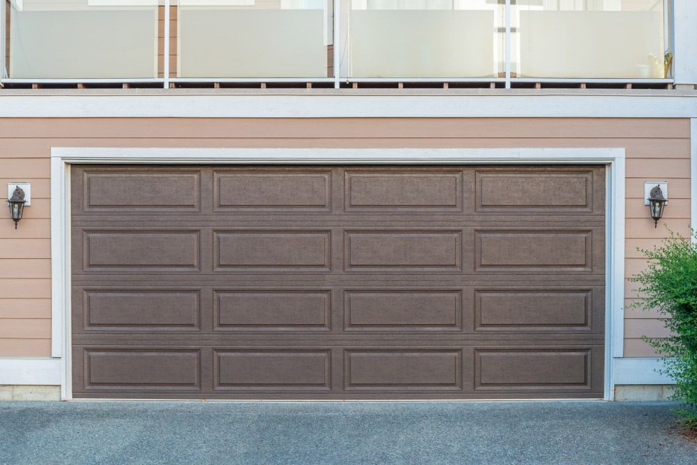 A Brown Garage Door is on the Side of a House — Hastings Garage Door Services in Port Macquarie