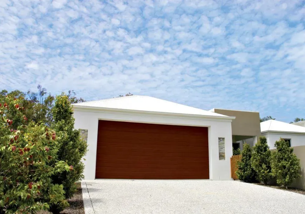 A white house with a brown garage door— Hastings Garage Door Services in Port Macquarie