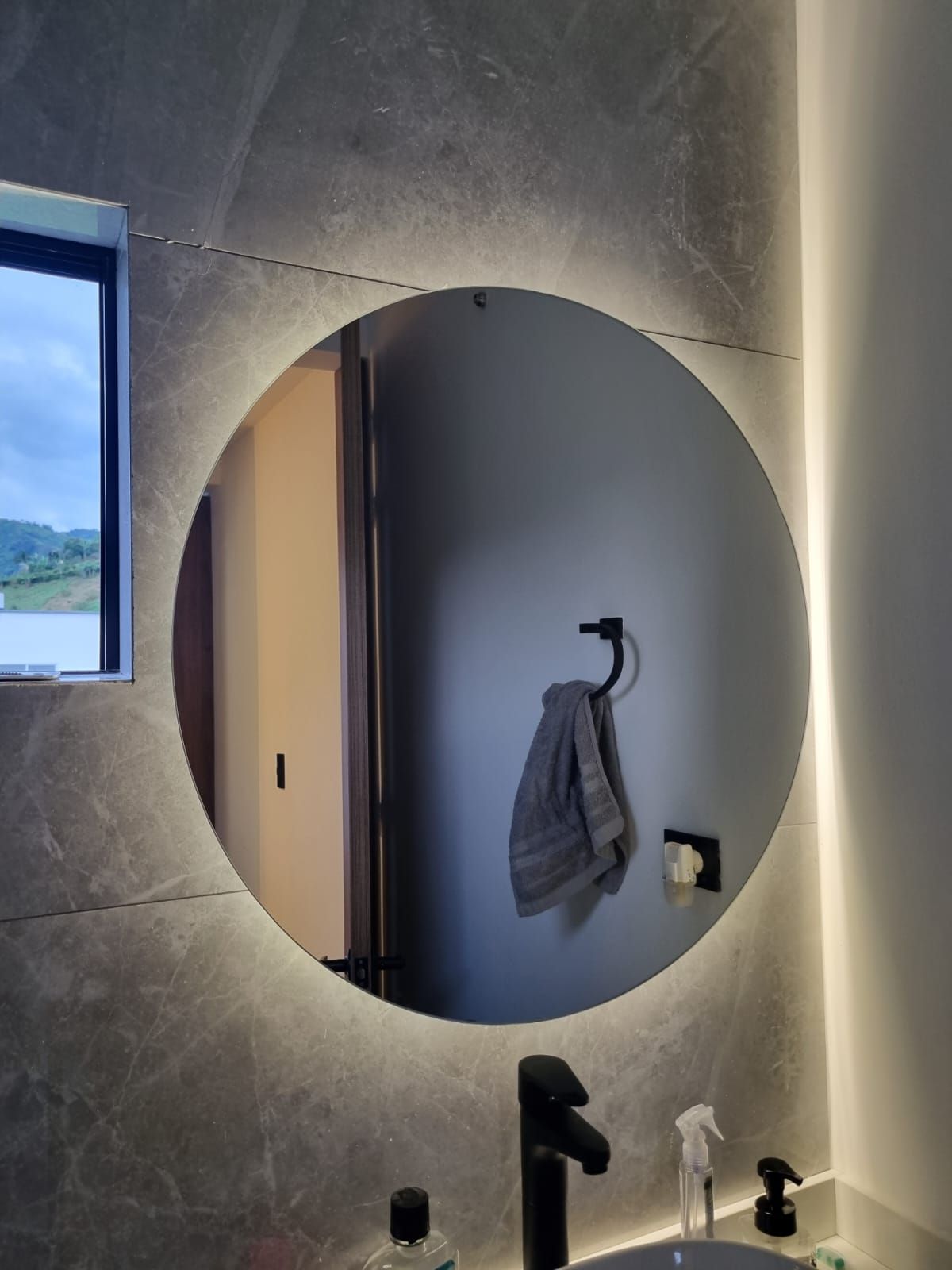 Primer plano de un marco de ventana moderno de color gris y del borde de una ventana de doble cristal contra una pared blanca.
