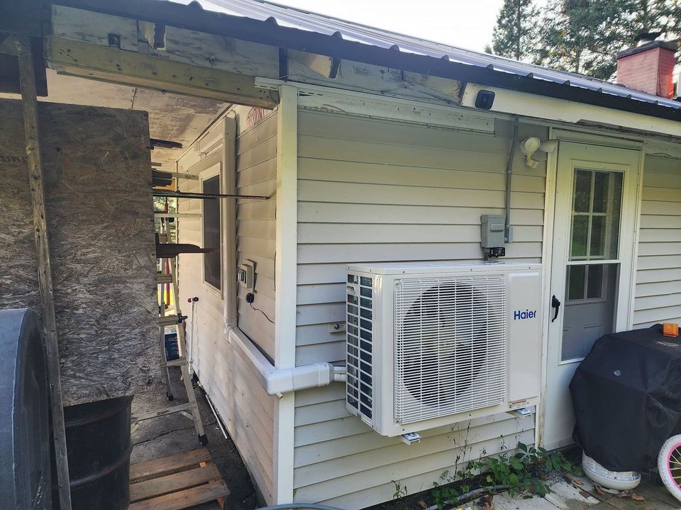 Exterior of a house with a wall-mounted air conditioner under a covered porch