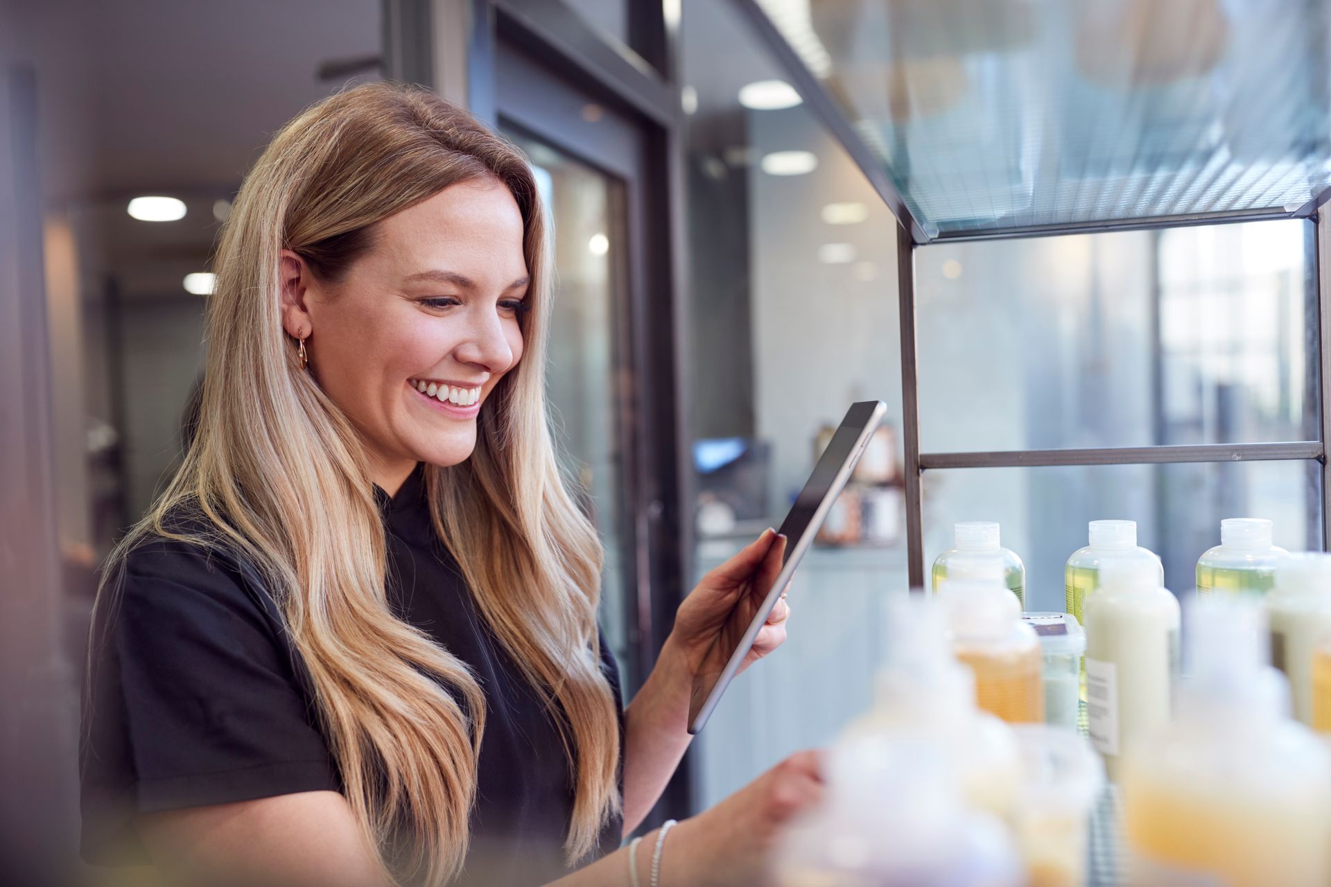 Eine Frau benutzt in einem Schönheitssalon ein Tablet.