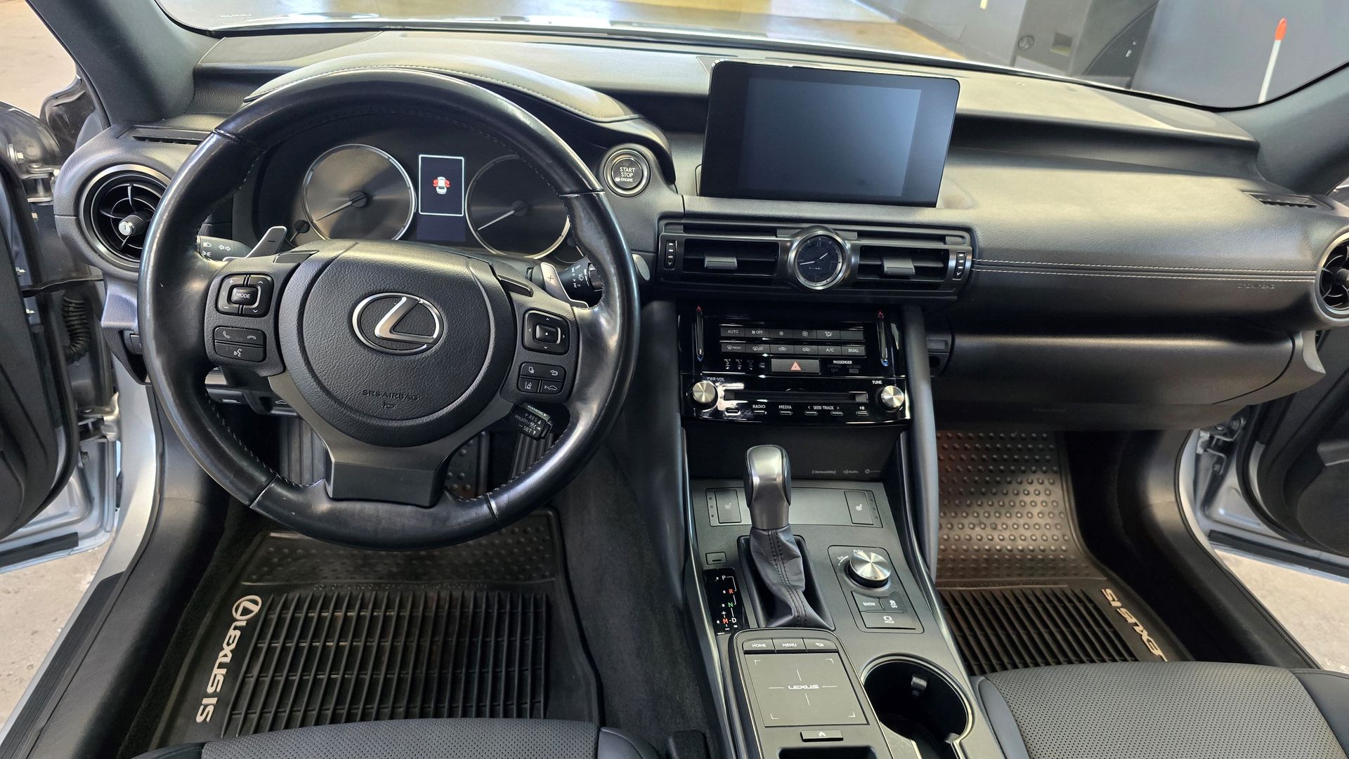 A person is cleaning the dashboard of a car with a brush.