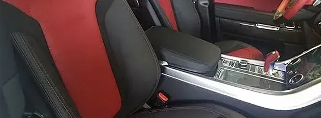The interior of a car with red seats and a black console.