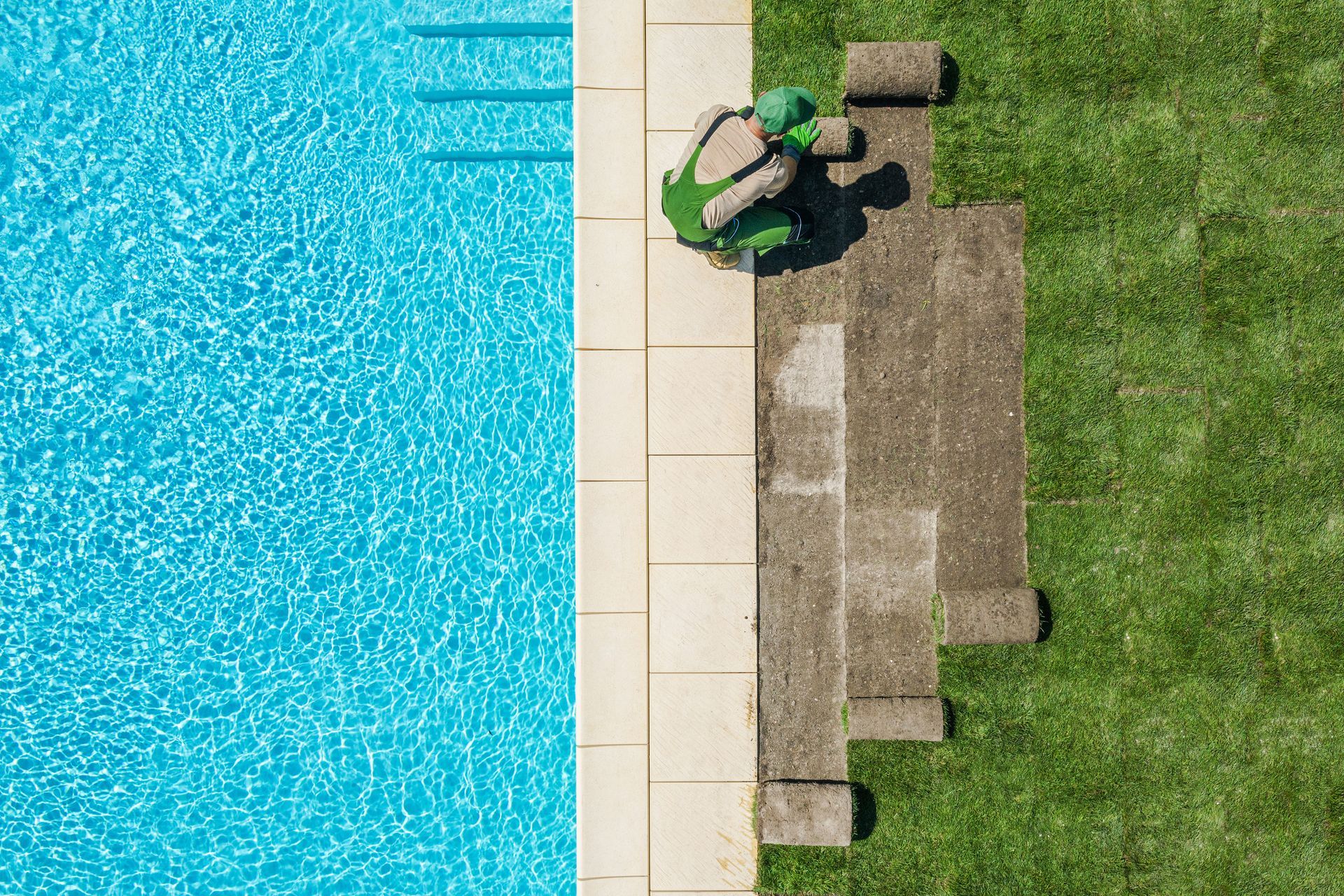 Landscaper installing fresh sod turf alongside a swimming pool. Landscaper installing fresh sod turf alongside a swimming pool.