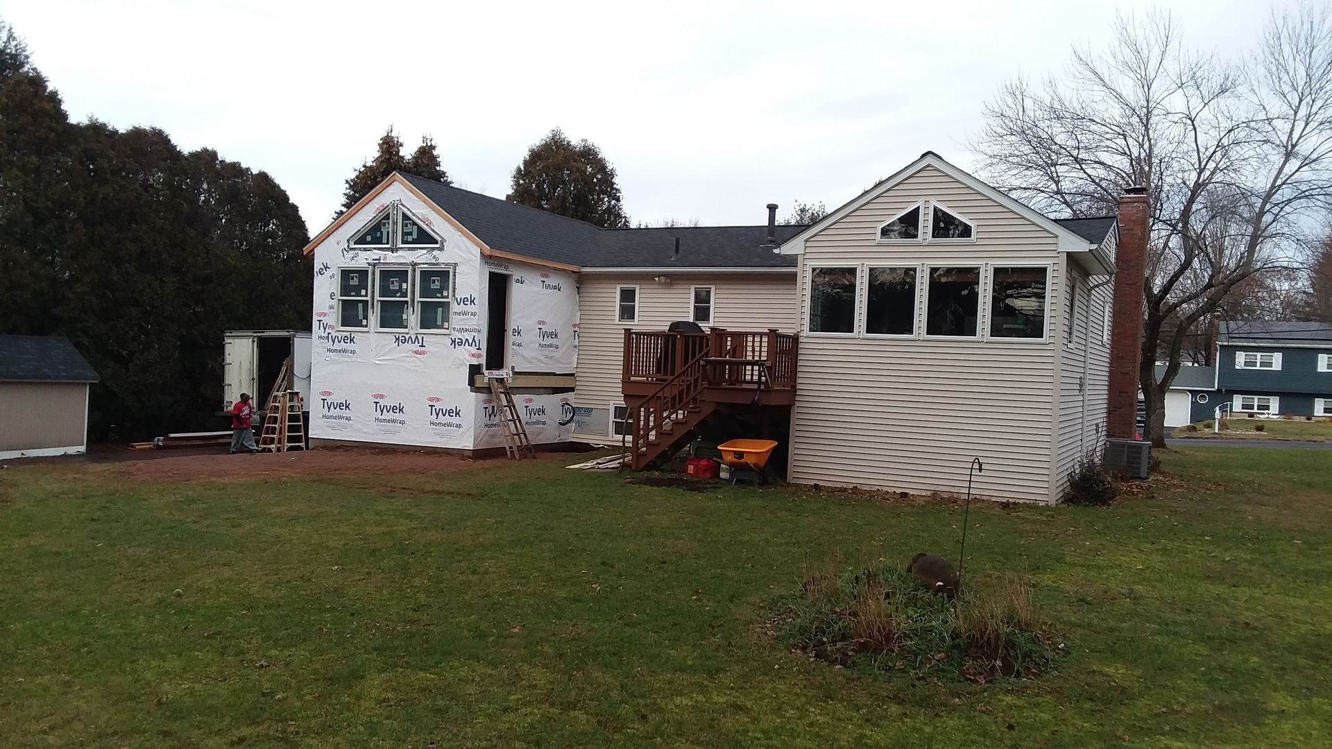 Back of a house undergoing construction with exposed sheathing and a deck.