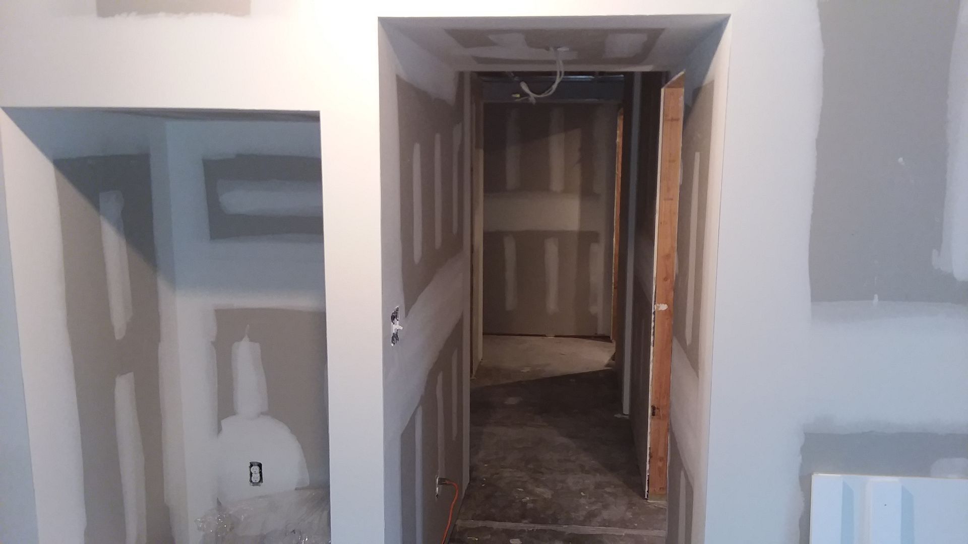 Interior construction view with doorway and wall openings, drywall, and unfinished surfaces.