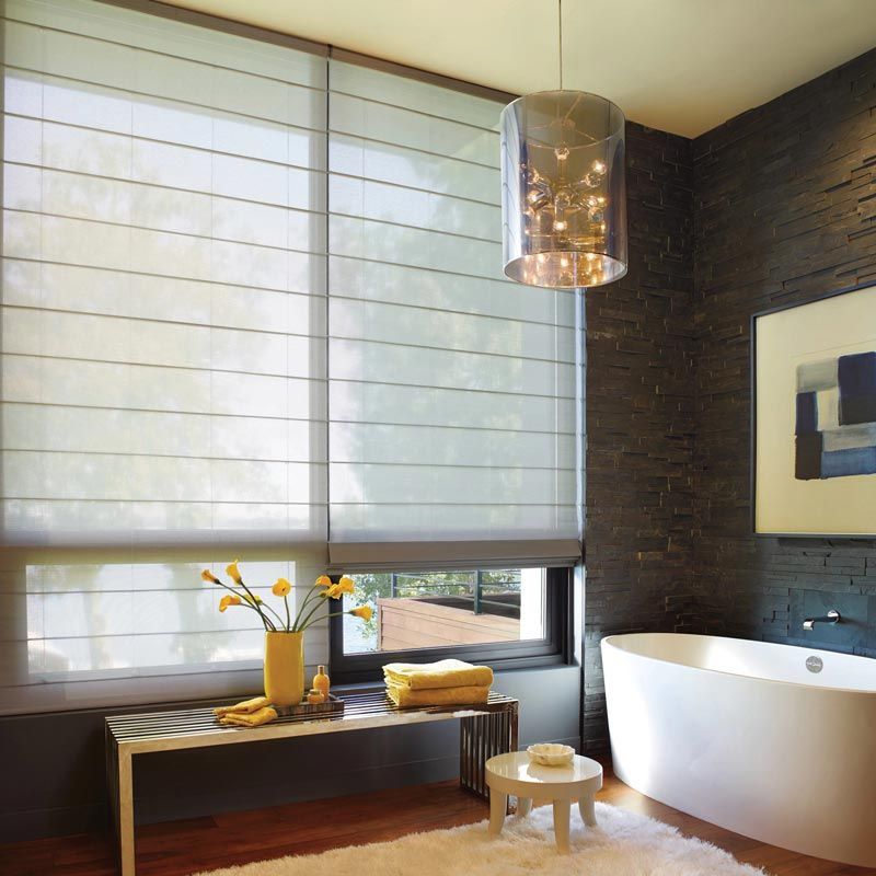Modern bathroom with freestanding tub, window bench, and soft gray shades
