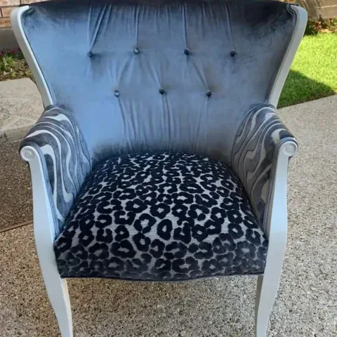 Gray tufted armchair with leopard-print seat cushion on a patio.