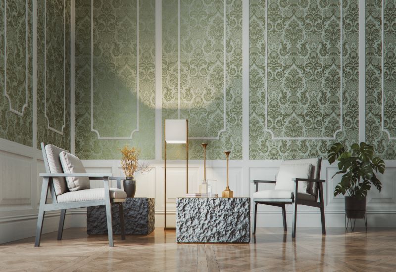 Elegant living room with floral wallpaper, black fireplace, dark sofa, patterned chairs, and wood floor