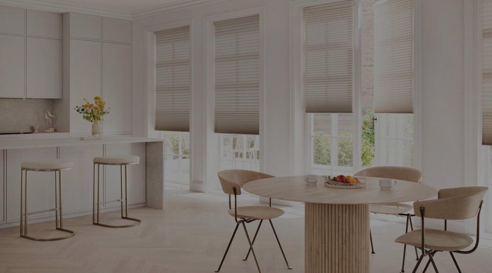 Bright white dining room with round table, chairs, bar stools, and sheer curtains in a modern home