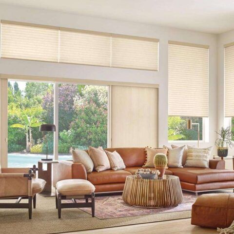 Bright modern living room with tan sectional sofa, large windows, and natural light.