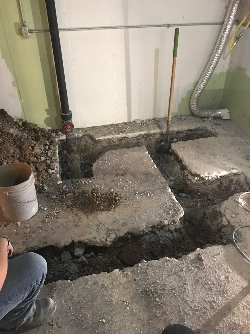 Excavated concrete floor with trenches and exposed dirt in a utility or renovation area