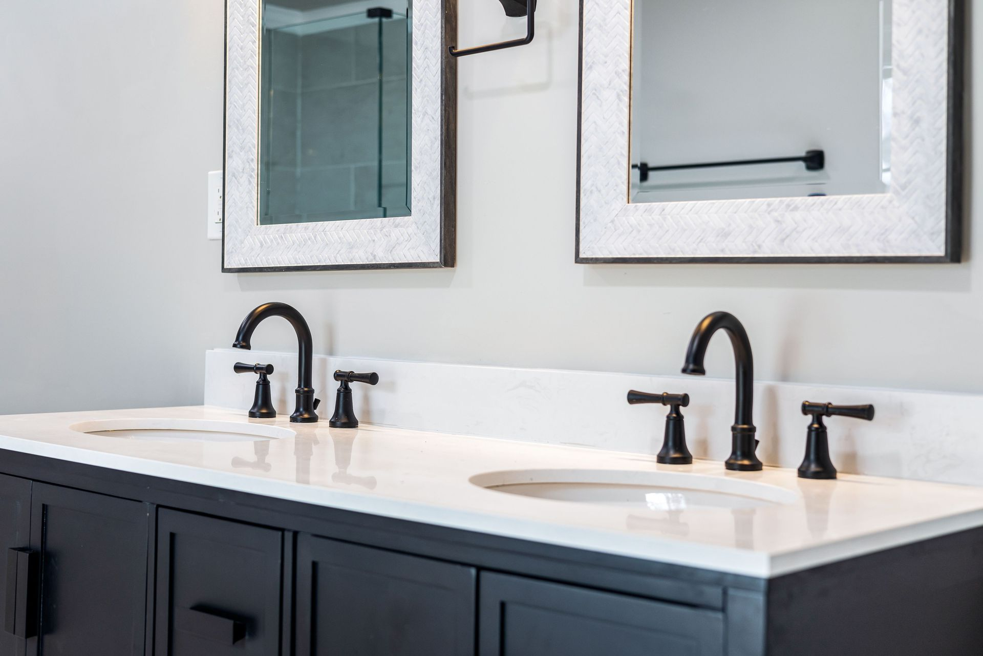 Small bathroom with white vanity, black faucet, large mirror, window, and toilet.