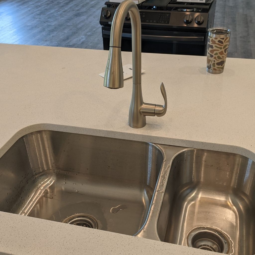 Stainless steel double sink with chrome faucet on a kitchen countertop