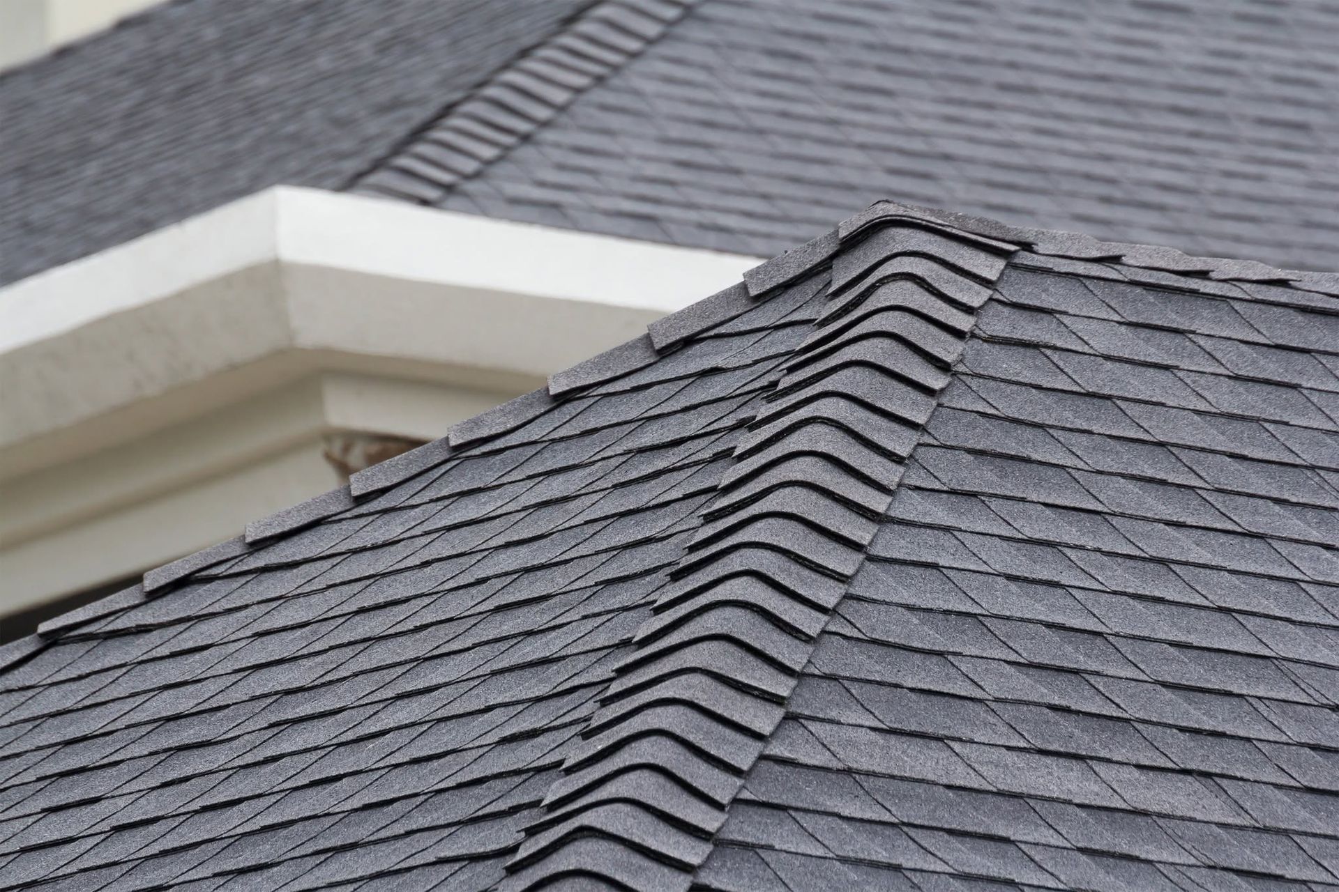 Gray shingled roof with a white dormer and roof peak detail