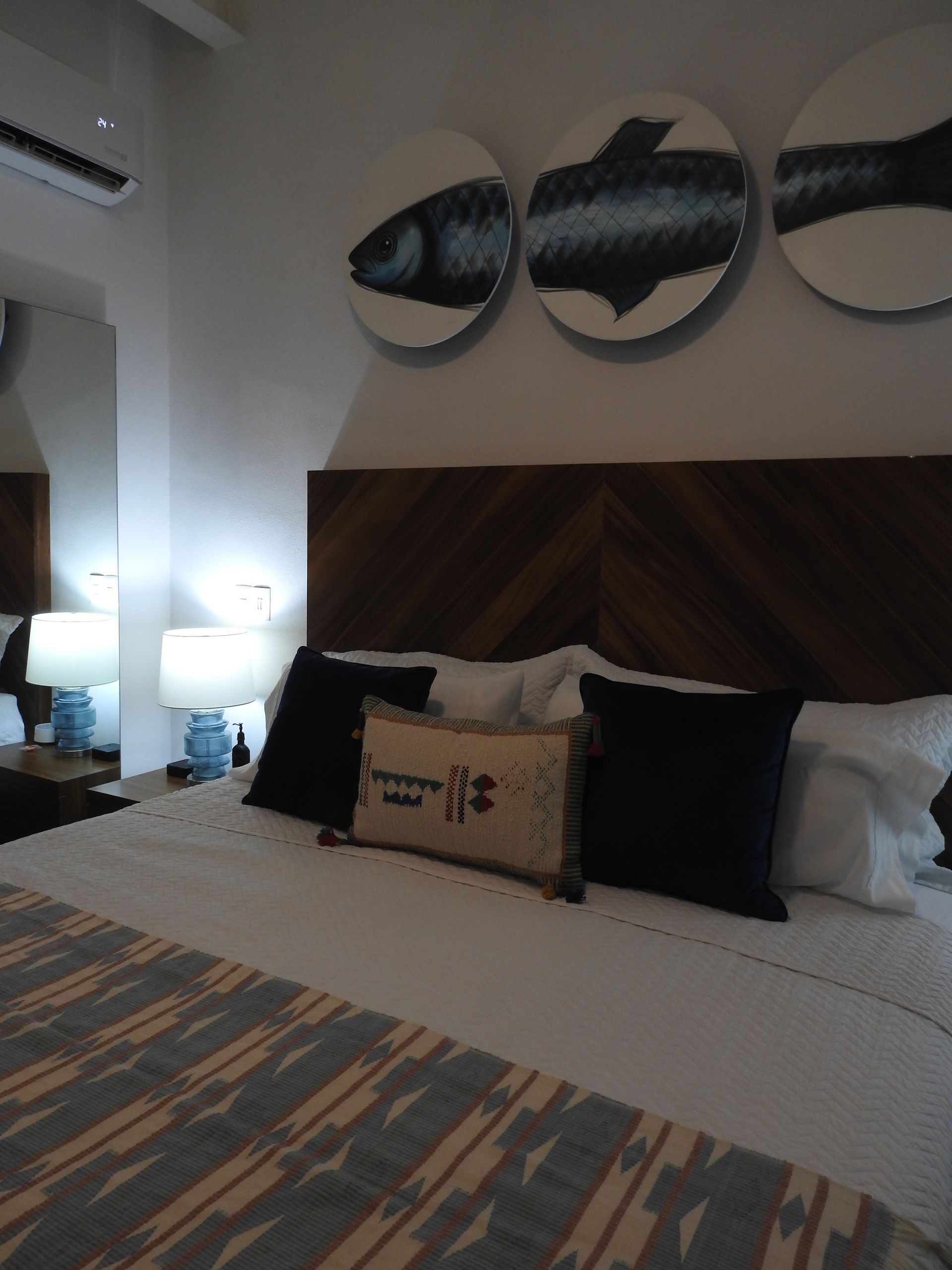 Twin Tide king bed with bedside lamps and fish artwork