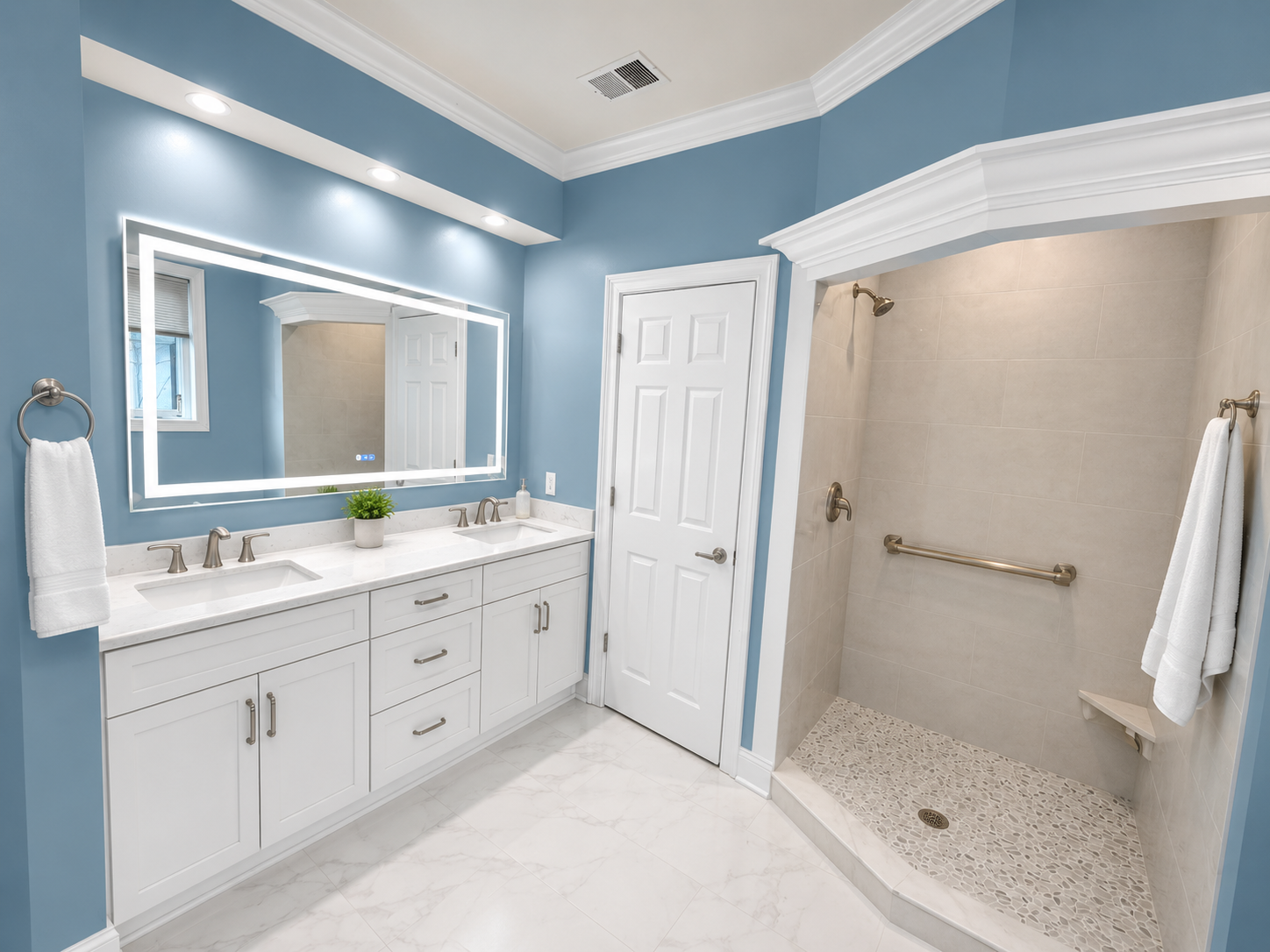 Bright blue bathroom with white vanity, large mirror, and open walk-in shower.