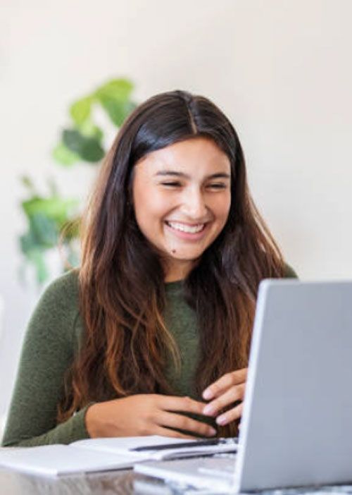 Student smiling while working on her laptop