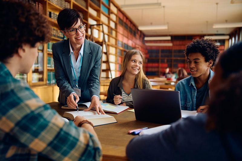 Established counselor working with students in a library