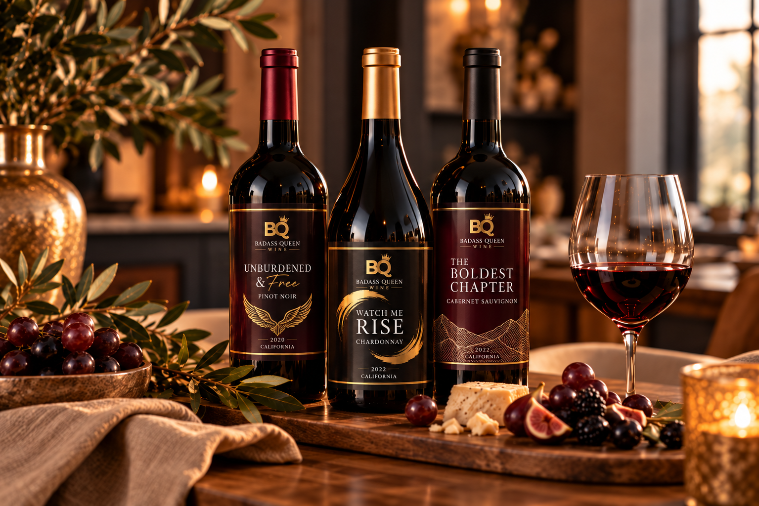 Three wine bottles on a rustic table with grapes, cheese, and a filled wine glass in warm candlelight
