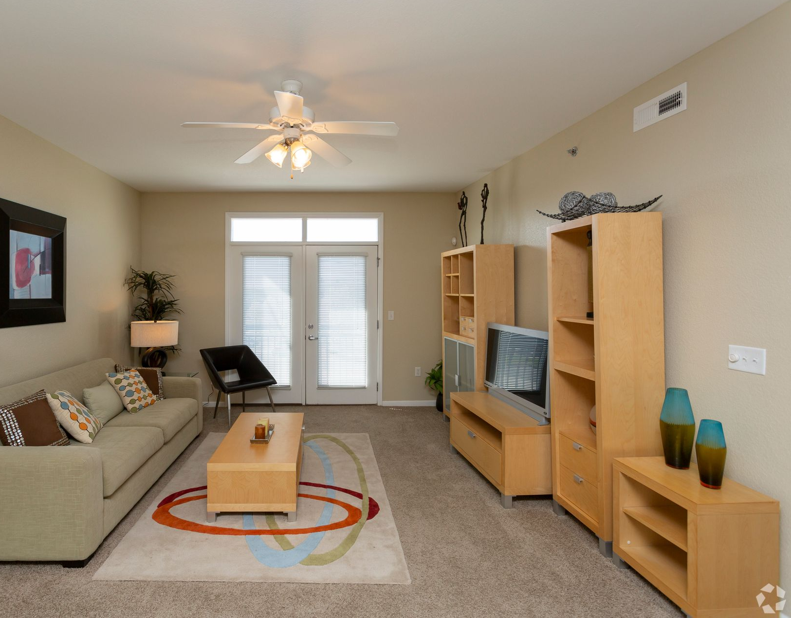 Living room with sofa, coffee table, entertainment center, and door to a balcony.