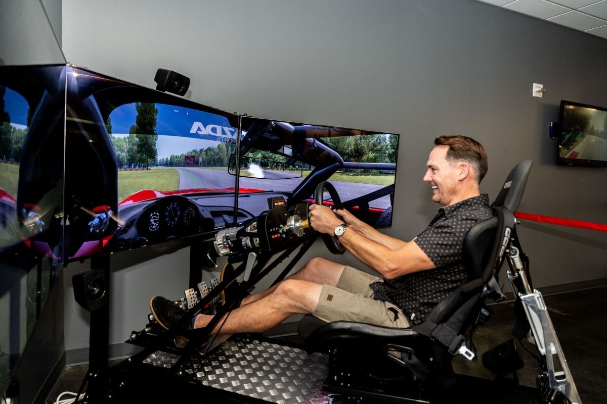 A man is sitting in a simulator playing a video game.