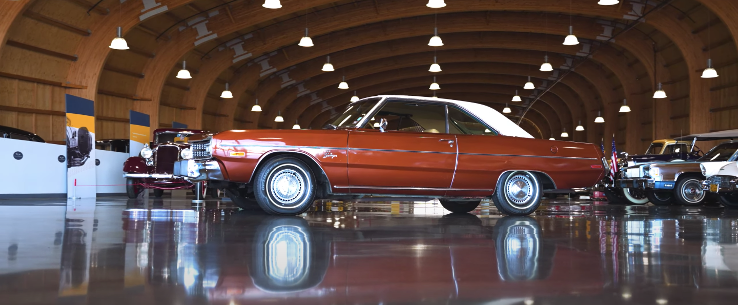 A red car is parked in a garage with other cars