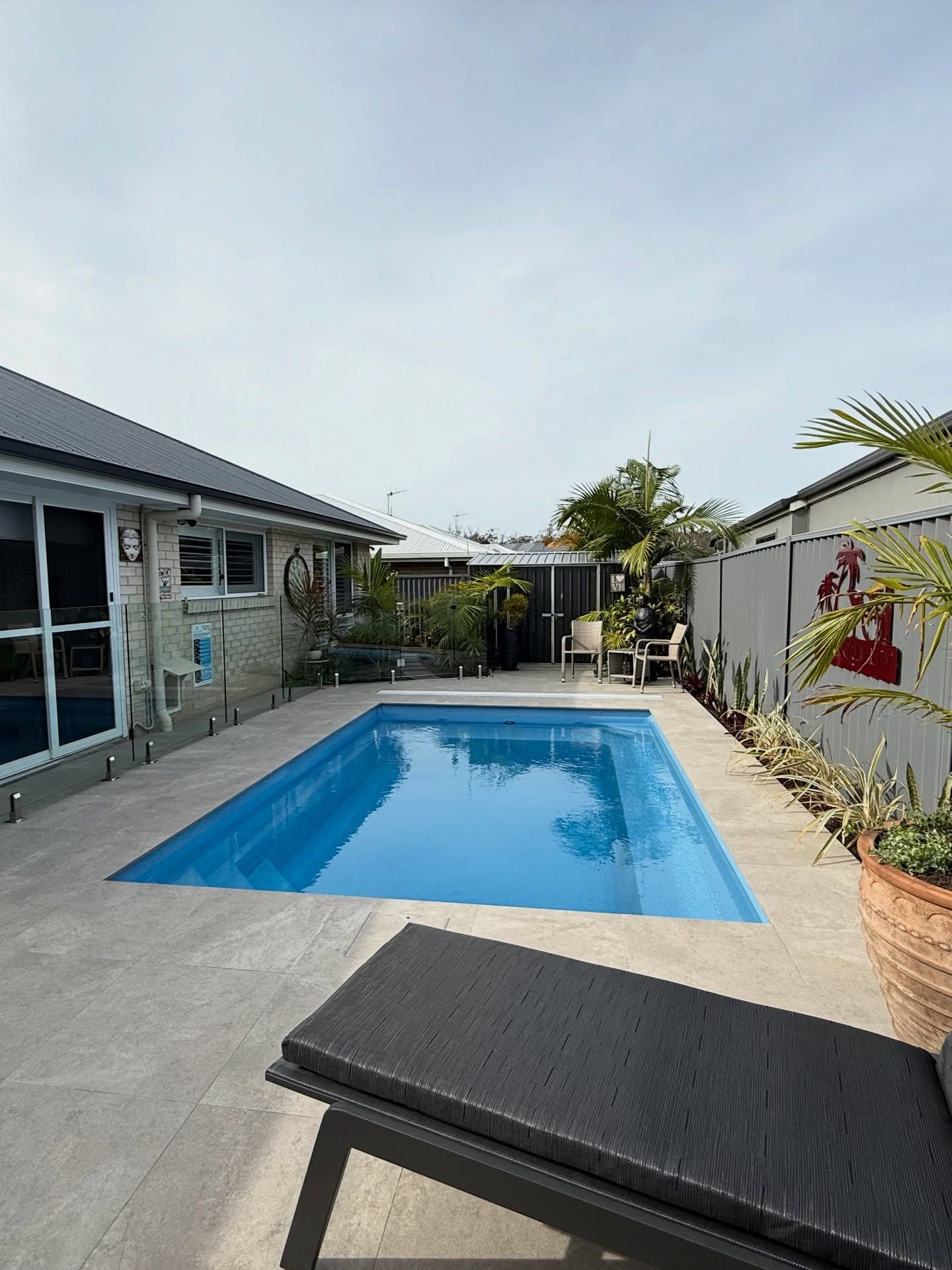 Backyard Patio with A Blue Swimming Pool  and Tropical Plants Between Two Houses — New Vision Pools in Port Macquarie, NSW