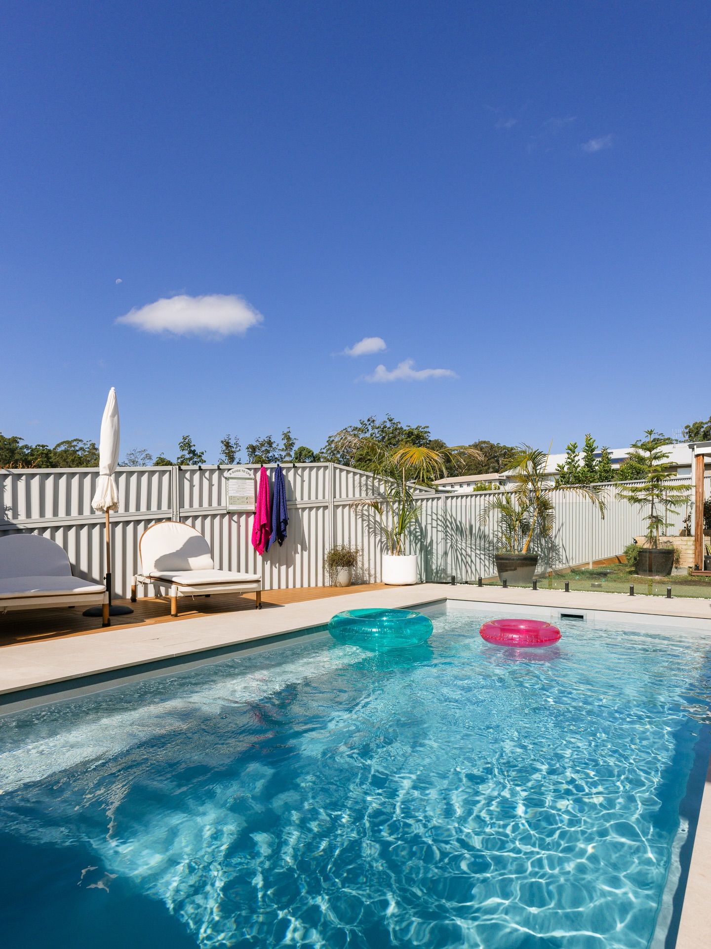 Backyard Pool with Lounge Chairs and Pink Float Under a Clear Blue Sky — New Vision Pools in Port Macquarie, NSW