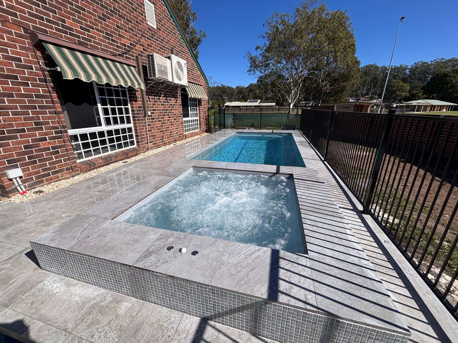 Rectangular Pool Beside a Brick House and Black Fence — New Vision Pools in Port Macquarie, NSW