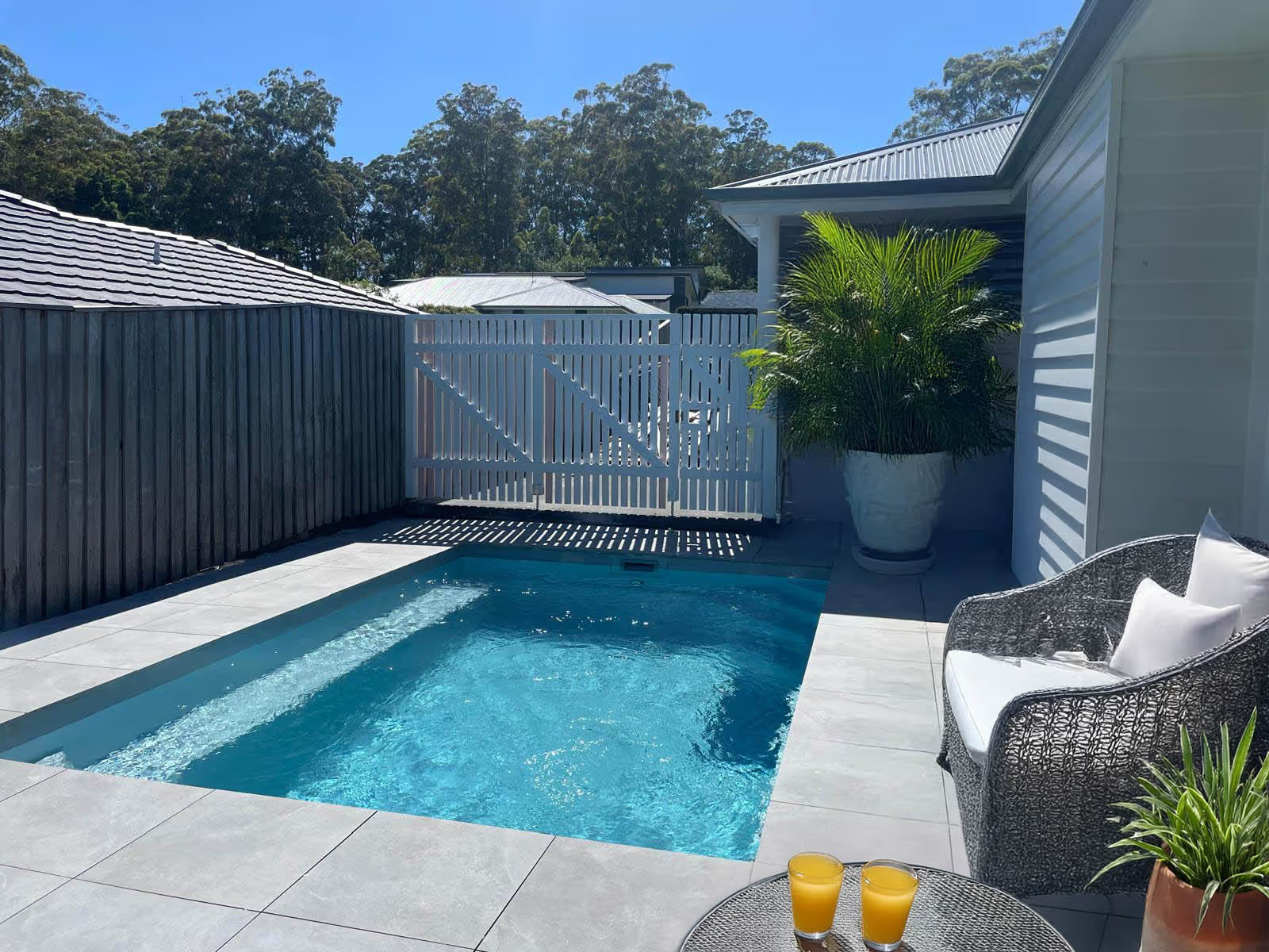 Backyard Pool with White Gate and Woven Lounge Chair — New Vision Pools in Port Macquarie, NSW