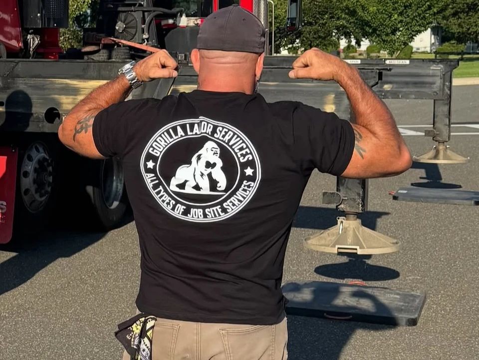 Man flexing biceps, wearing a black shirt with