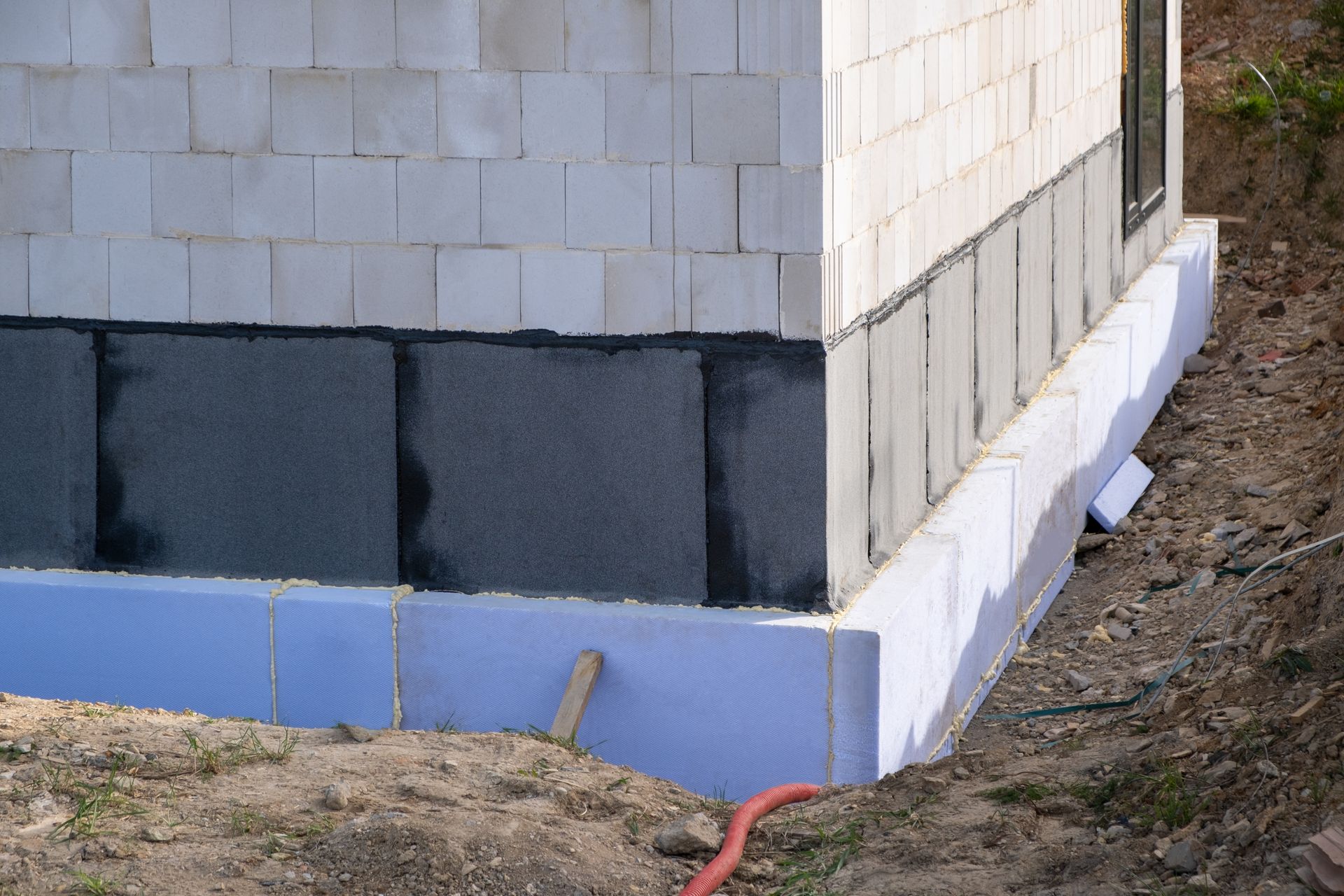 The corner of a building is being built with a blue foam foundation.
