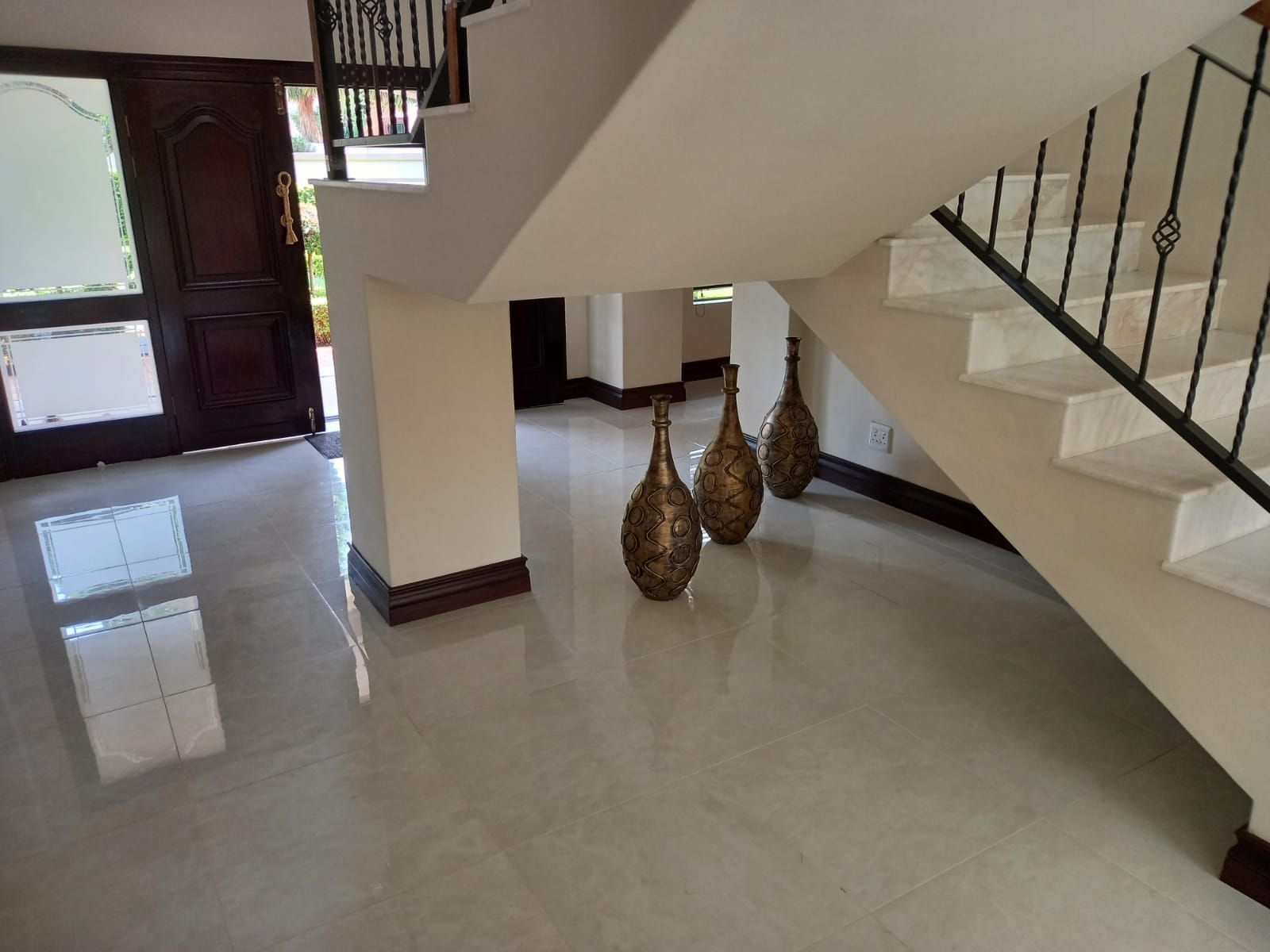 A staircase in a house with vases on the floor