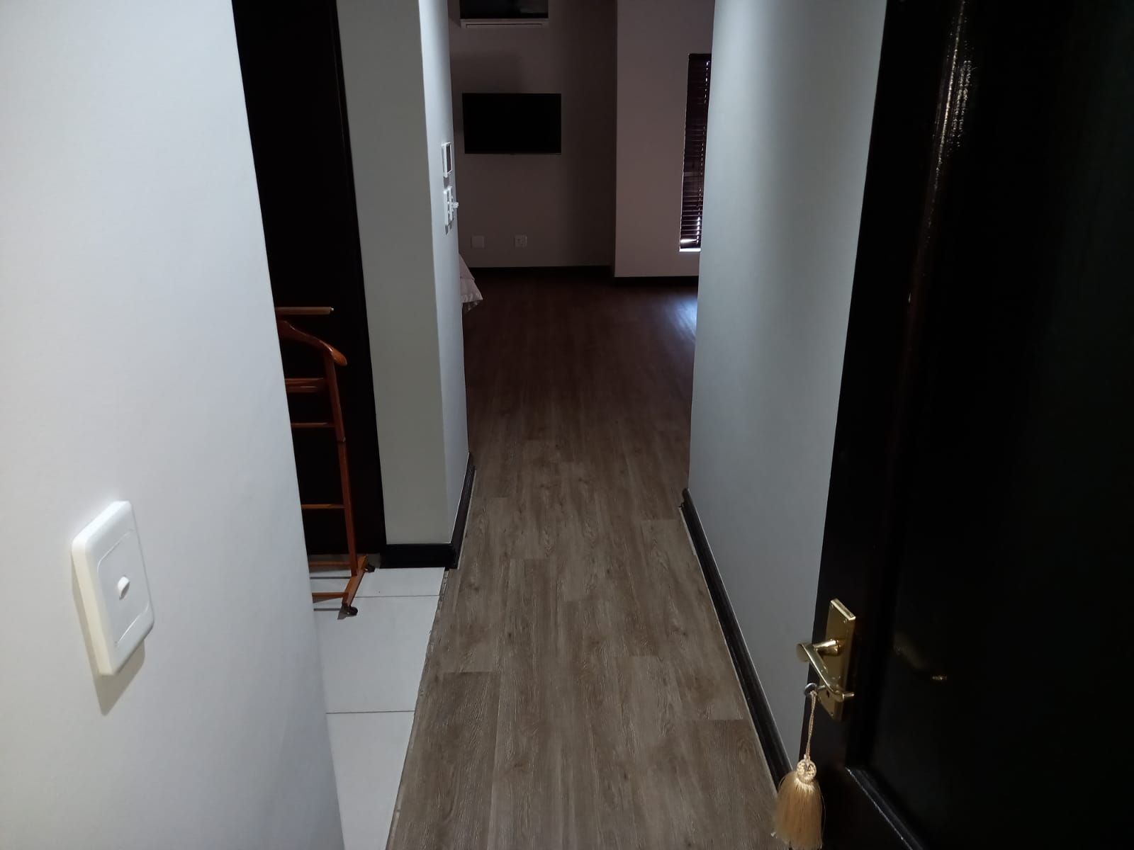 A hallway with wooden floors and a black door