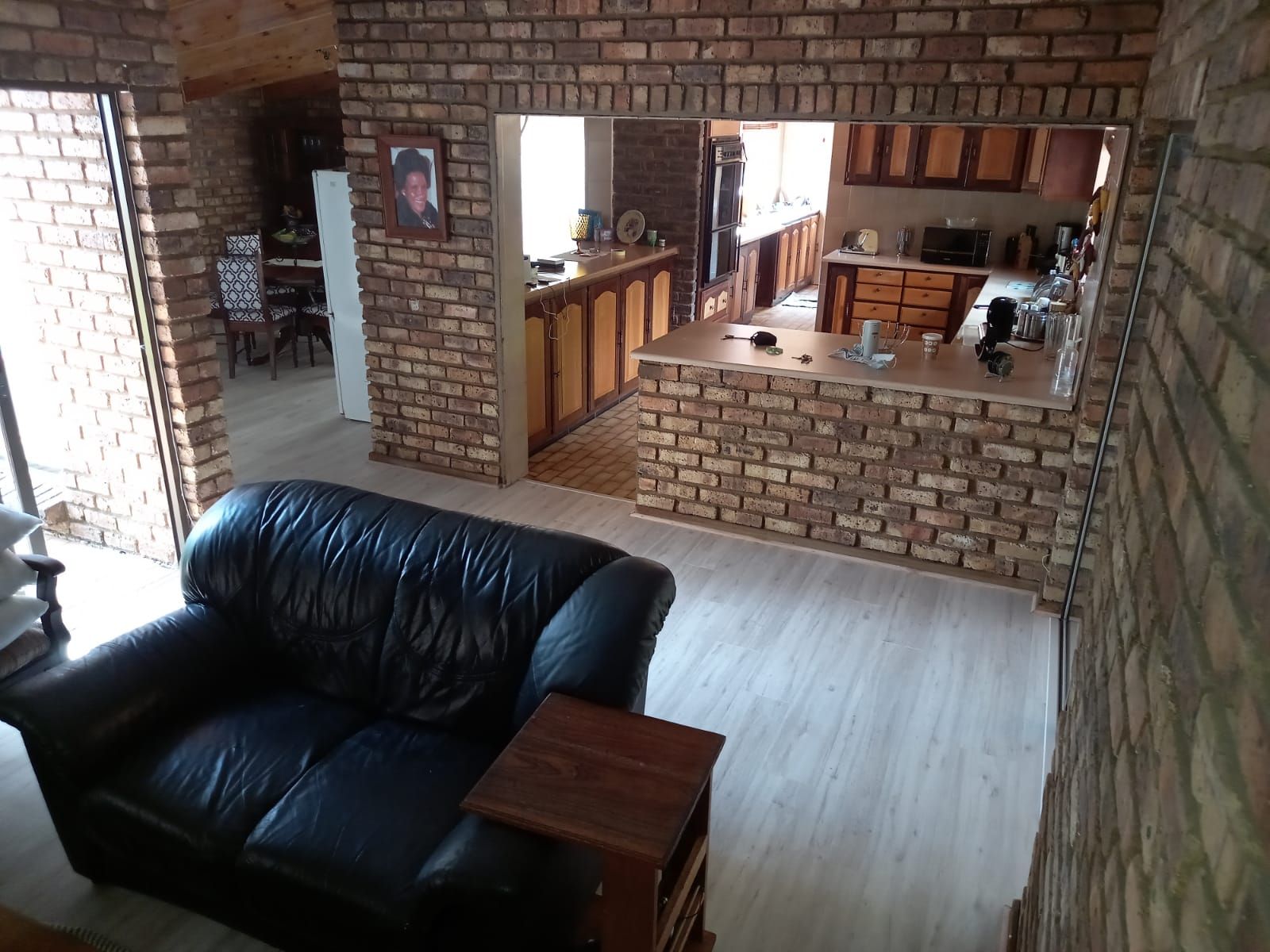 A living room with a black couch and a brick wall