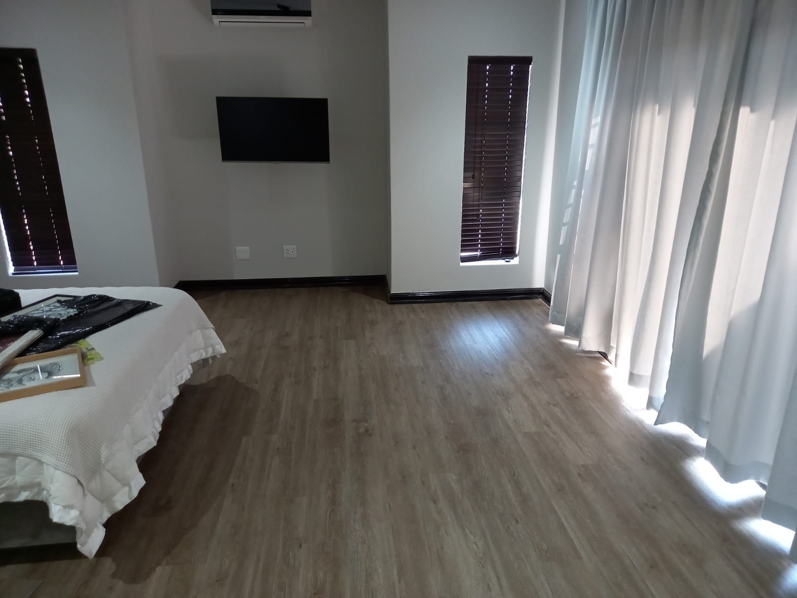 A bedroom with a bed and a television on the wall