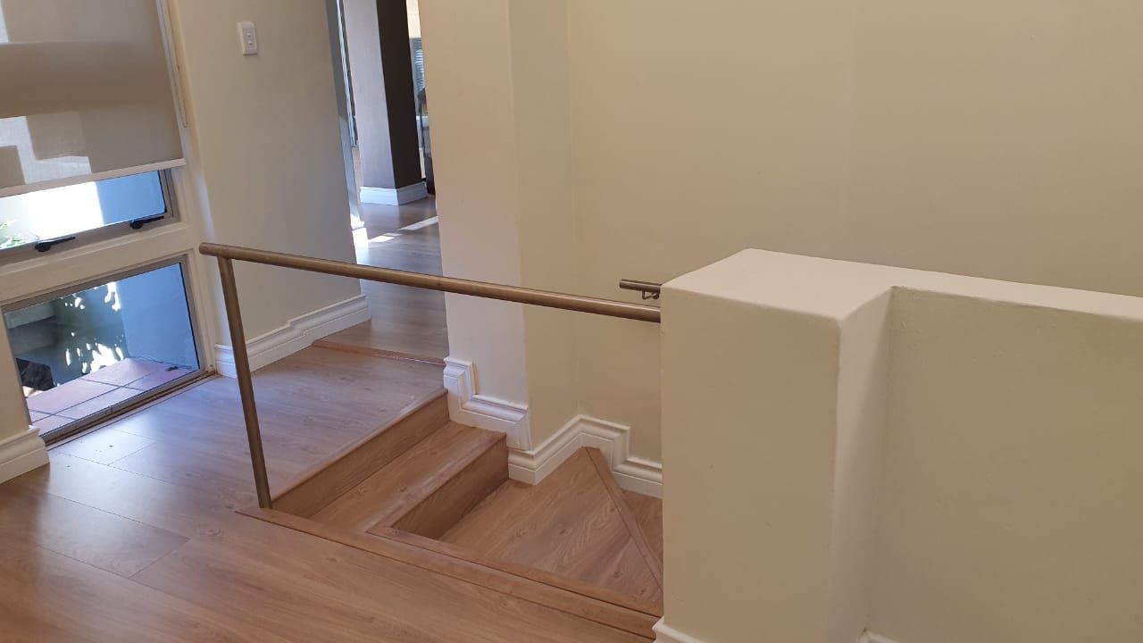 A staircase with wooden steps and a metal railing in a house.